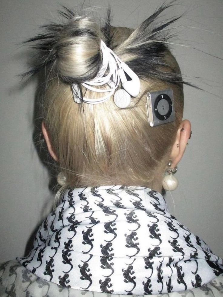 Blonde person with a messy bun styled with white earbuds and a silver iPod Shuffle clipped into hair.