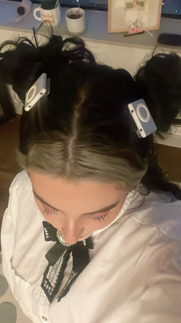 Girl with space buns styled with two white iPod Shuffles clipped into her hair.