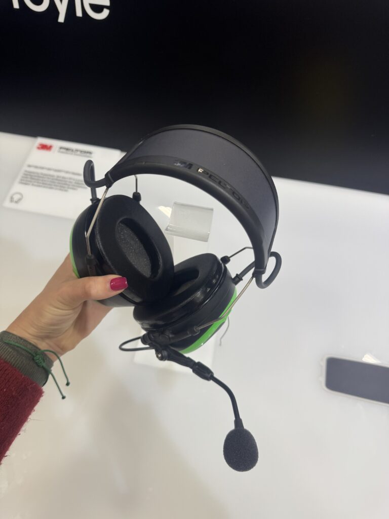 A sturdy pair of over-ear headphones with a built-in microphone held by a hand. The design, from Exeger, focuses on durability and comfort, with adjustable padding and a robust frame. Perfect for professional use, these headphones offer clear audio quality and reliable communication, ideal for challenging environments.