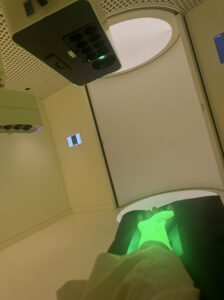 A glowing green laser scans a patient’s hand, illustrating Neko Health’s high-tech equipment for gathering precise health data.
