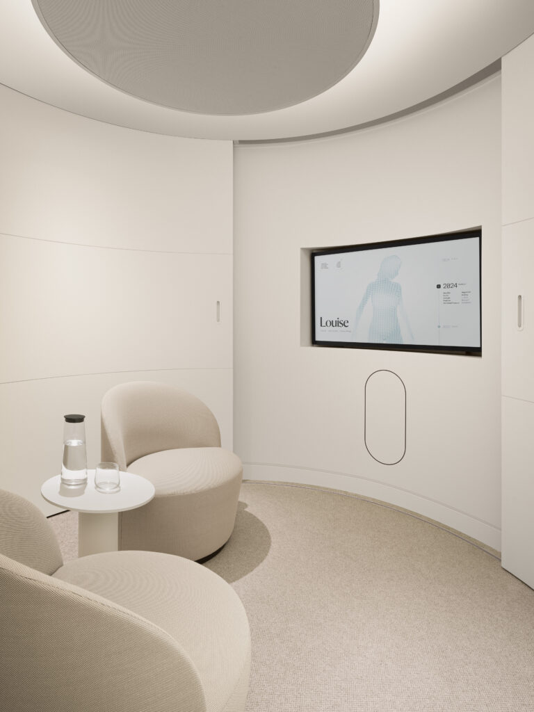 A private consultation room with curved beige chairs, soft lighting, and a sleek wall screen displays personalized health data for in-depth doctor-patient discussions.