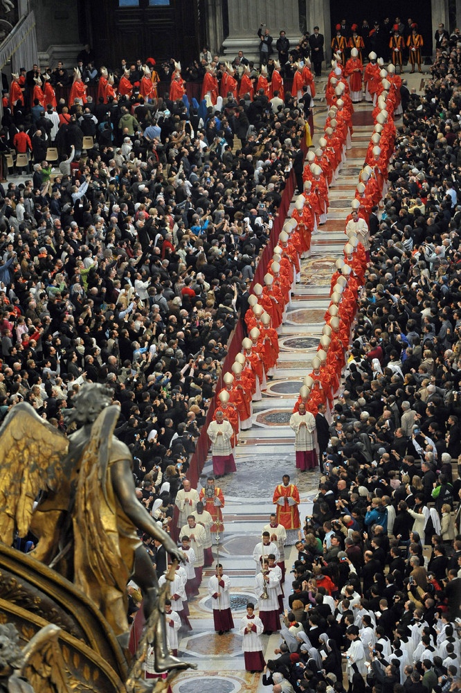 This may contain: a large group of people in red and white outfits walking down a street with many other people