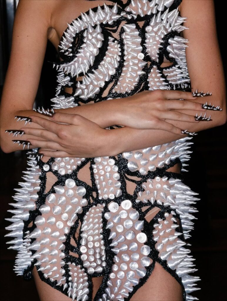 Detailed view of Karina Bond’s 3D-printed spiked monochrome dress with matching nail art at London Fashion Week.