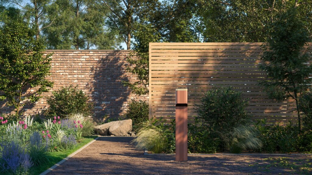 A slim terracotta-toned EV charger standing in a landscaped garden with wooden fencing and plants, showing how design and sustainability meet in outdoor tech.