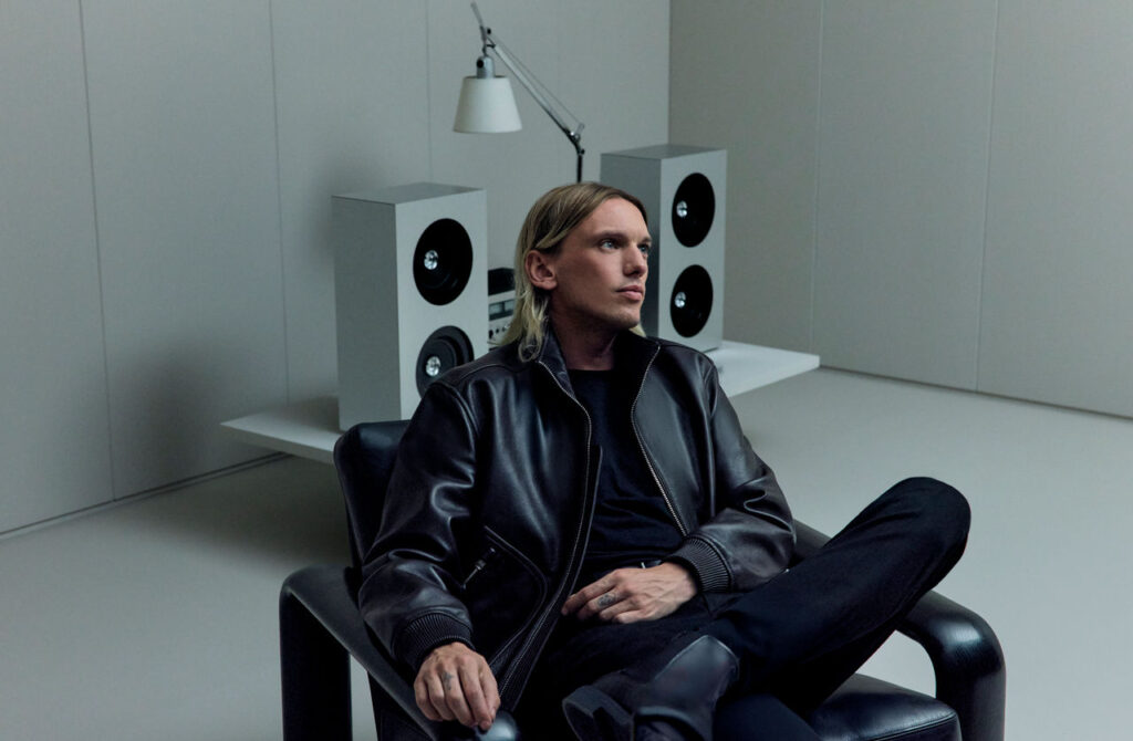 Jamie Campbell Bower in leather jacket campaign imagery for BOSS immersive F1 experience.