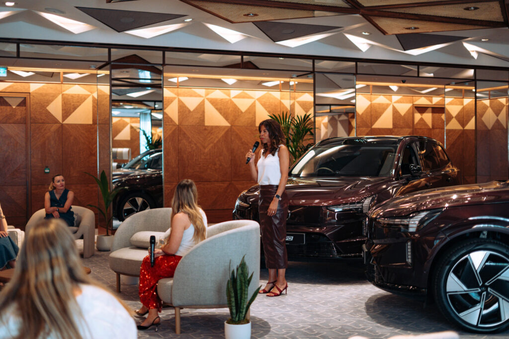 Nicole Melillo Shaw and Natasha Bird speaking at Volvo’s Power and Pause event at The Berkeley, with Volvo electric cars in the background.
