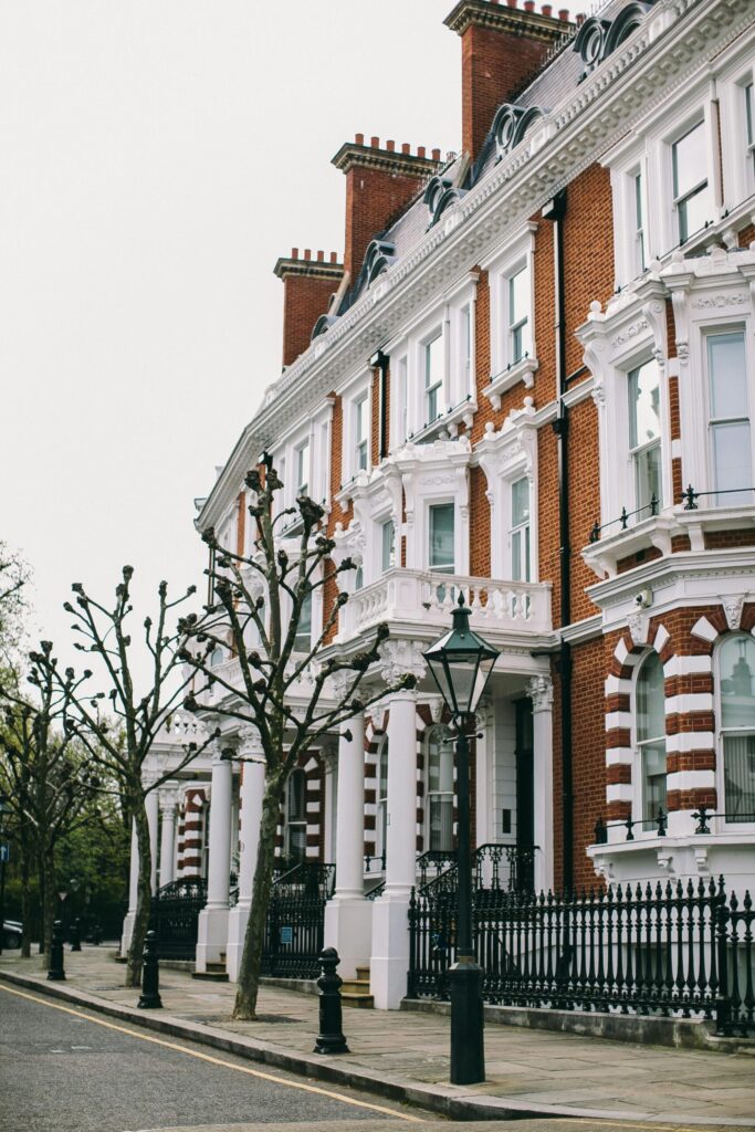 Elegant red-brick and white-trimmed Georgian townhouses lining a quiet London street, symbolising luxury real estate and the city’s prime property market.