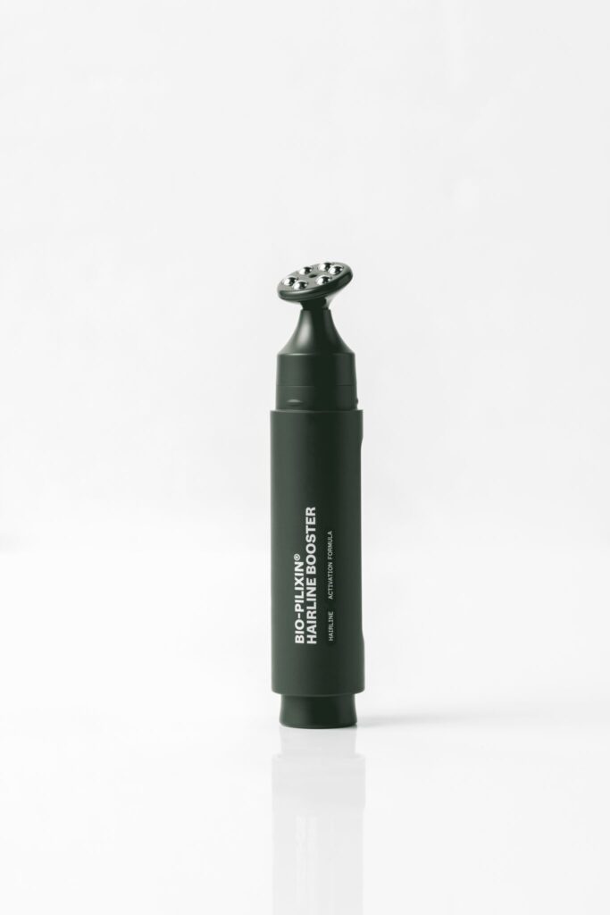 A close-up image of the Scandinavian Biolabs Bio-Pilixin Hairline Booster applicator pen with stainless steel roller, designed to strengthen and protect the hairline.