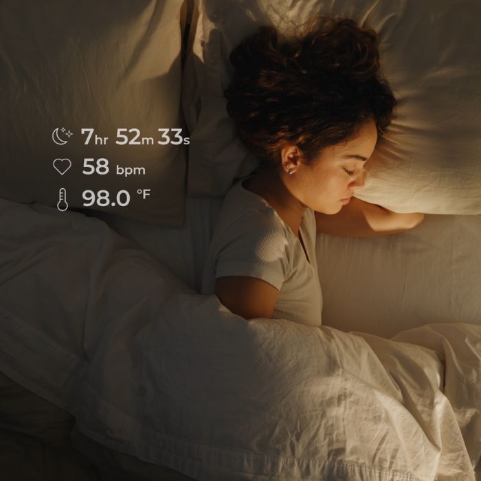 A woman sleeping peacefully while wearing Lumia smart earrings, with on-screen overlays showing heart rate, sleep duration, and temperature.