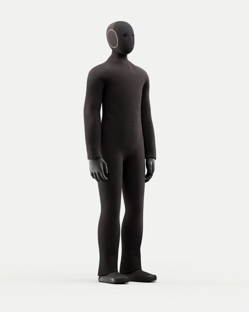 Full-length image of the NEO robot in dark grey, highlighting its streamlined, fabric-covered humanoid body design.