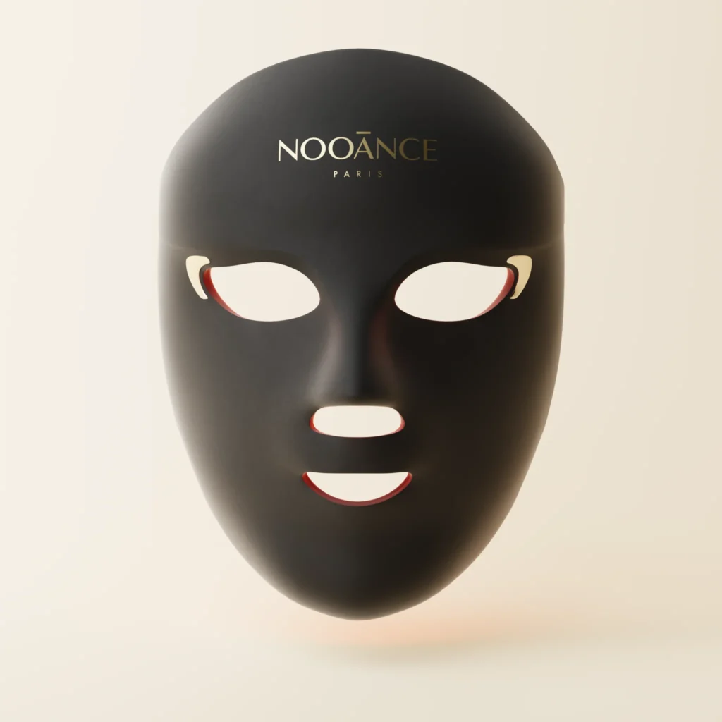 Image of the NOOĀNCE Paris Elite X600 LED Mask in a matte black limited edition finish, featuring cut-out eye and mouth openings and gold NOOĀNCE branding on the forehead.