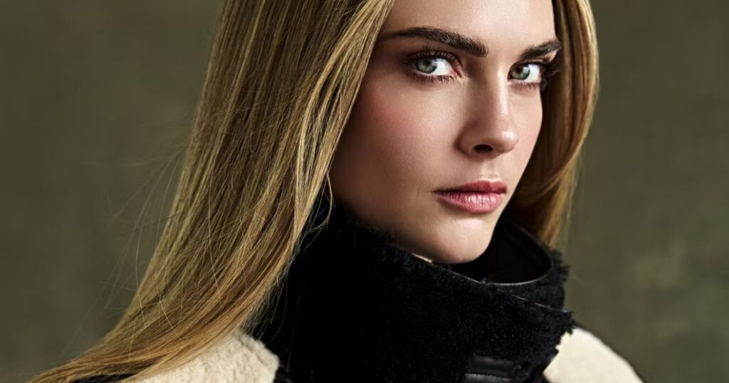 Close-up portrait of Cara Delevingne with sleek hair, natural makeup, and a high-collared shearling jacket.