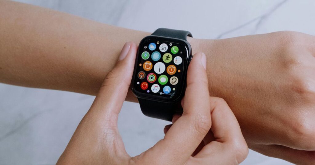 Close-up photo of a person wearing an Apple Watch showing multiple app icons, including WhatsApp, symbolising the new WhatsApp Apple Watch integration.