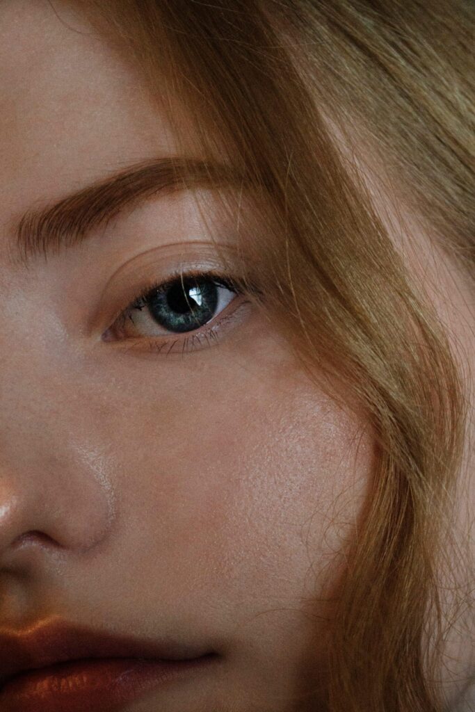 A close-up shot of a woman’s eye and natural blonde hairline, representing the Scandinavian hairline trend and hair health focus.
