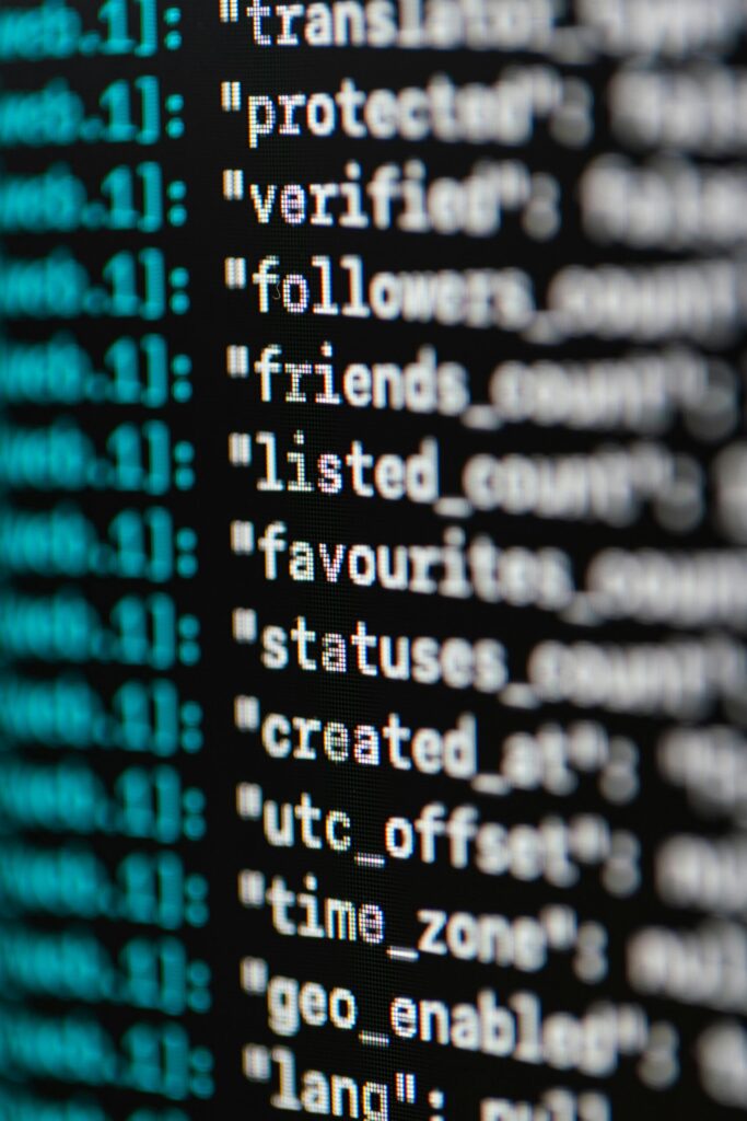 A macro shot of computer code displayed on a screen, showing lines of text and data fields - representing artificial intelligence and modern coding.