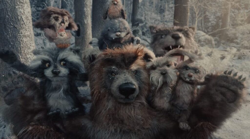 A group of woodland animal puppets standing together in a snowy forest scene from Apple’s festive film A Critter Carol.