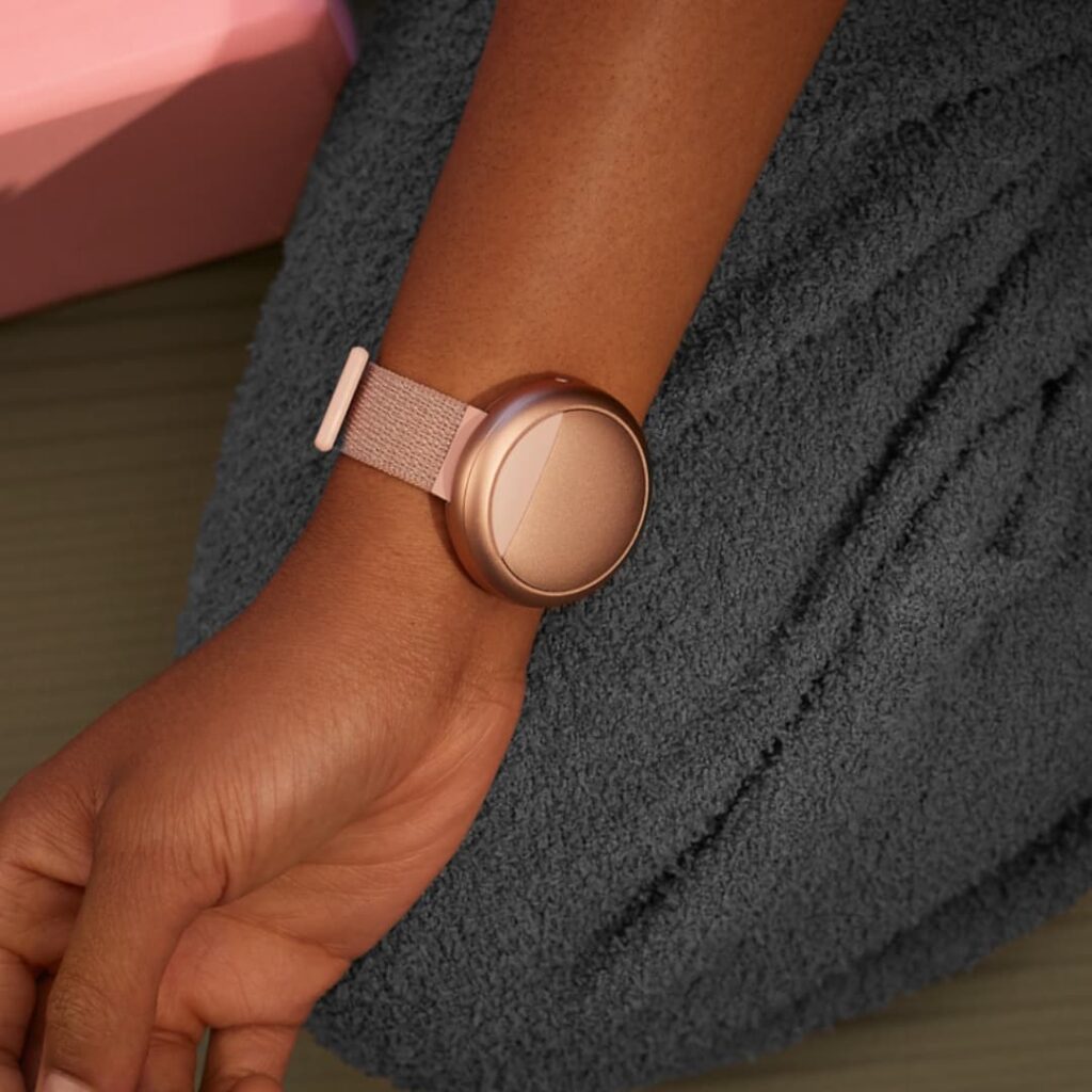 Close-up of the rose gold Embr Wave 2 wristband worn on the arm, showcasing a smart menopause wearable that delivers cooling and warming sensations to relieve hot flushes and night sweats.