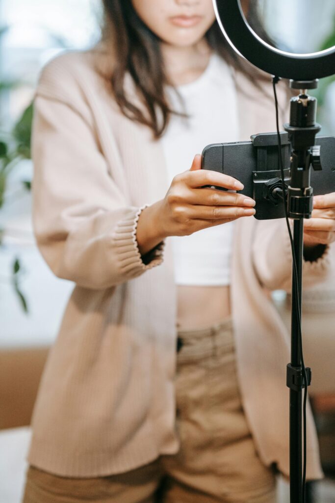 A content creator filming video content indoors using a smartphone and ring light, symbolising the professionalisation of influencer marketing, creator technology tools, and digital content production.