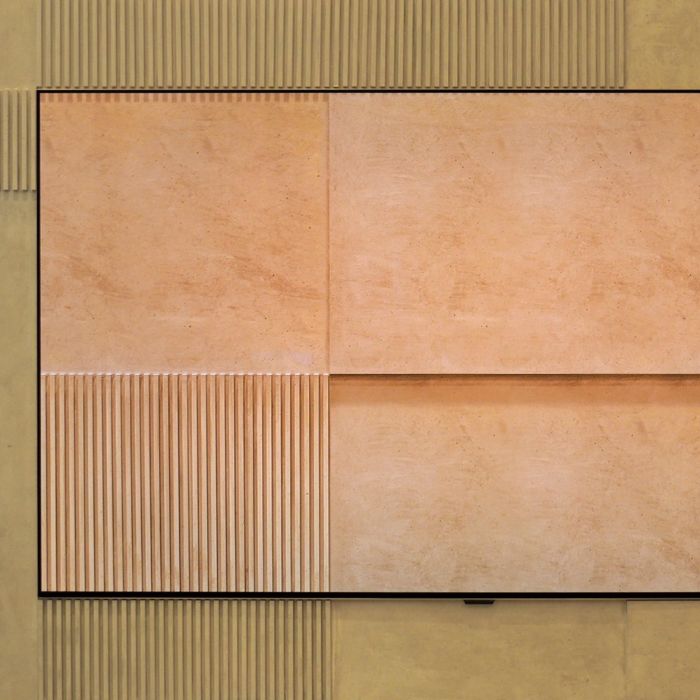 LG W6 Wallpaper OLED television mounted flush against a textured wall, showcasing ultra-thin screen design with hidden wireless connectivity.