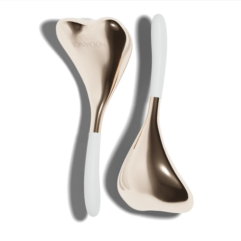 Pair of Nooānce Paris cryotherapy facial spoons designed for lymphatic drainage, de-puffing and facial massage, shown on a clean white background.
