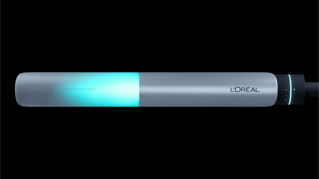 Studio image of the L’Oréal LightStraight+ hair styling tool with illuminated infrared light panel, showcasing advanced hair straightening technology and sleek metallic design.