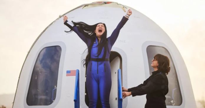 Amanda Nguyen raising her arms in celebration outside the Blue Origin space capsule following the suborbital flight, marking her historic achievement as the first Vietnamese woman in space and a milestone moment in commercial spaceflight.