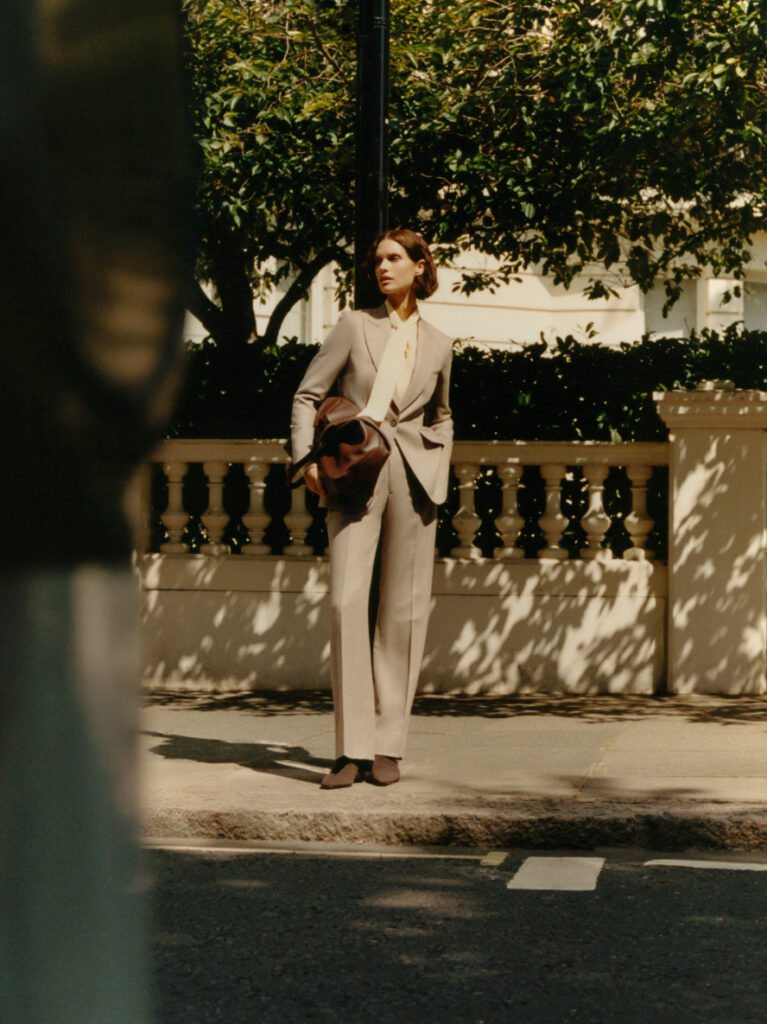 Full-length image of model wearing Knatchbull women’s tailored suit outdoors, showcasing contemporary Savile Row-inspired womenswear.