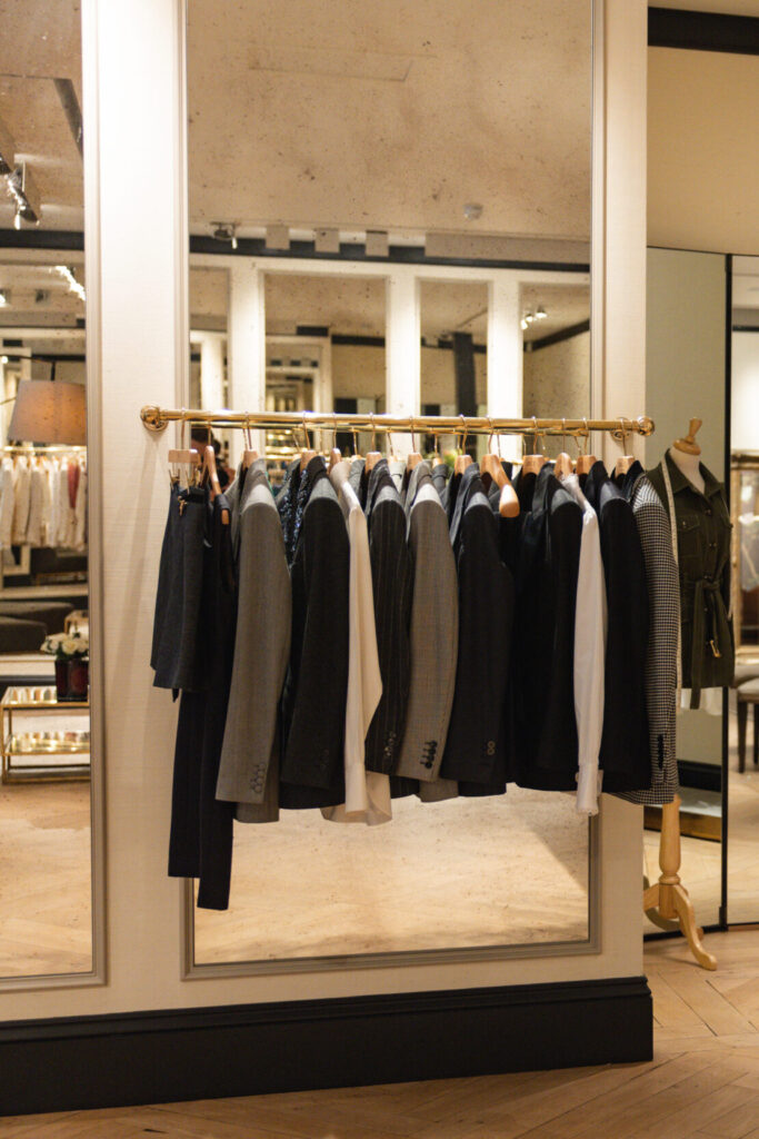 Interior of Knatchbull Savile Row store showing bespoke women’s tailoring space with suit racks, mirrors, marble counter and minimalist luxury design.