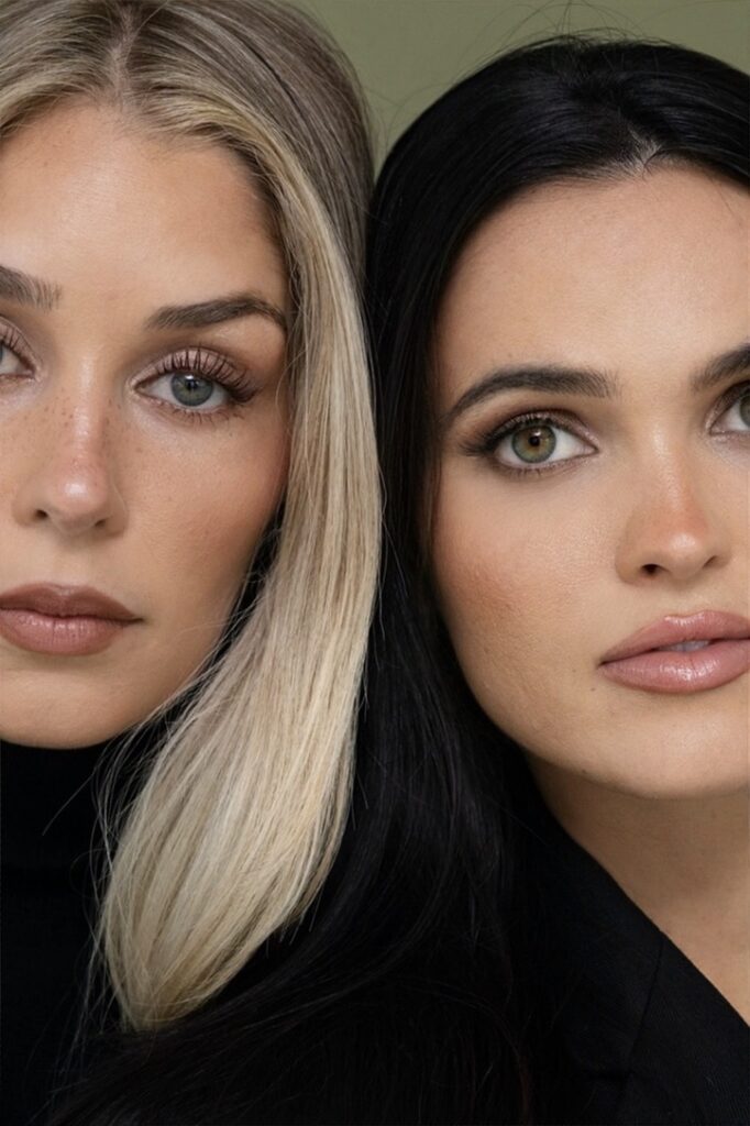 Close-up portrait of Kara Cooke, left, and Mary Holland Nader, right, both in black against an olive green backdrop
