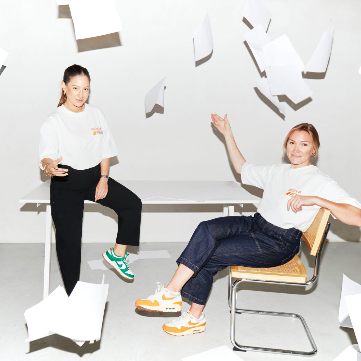 RISER co-founders Lamees Butt and Suz Bannister toss papers into the air in a bright studio, symbolising the end of outdated CVs and the rise of video-first hiring.